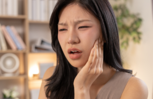 Woman holding jaw in pain
